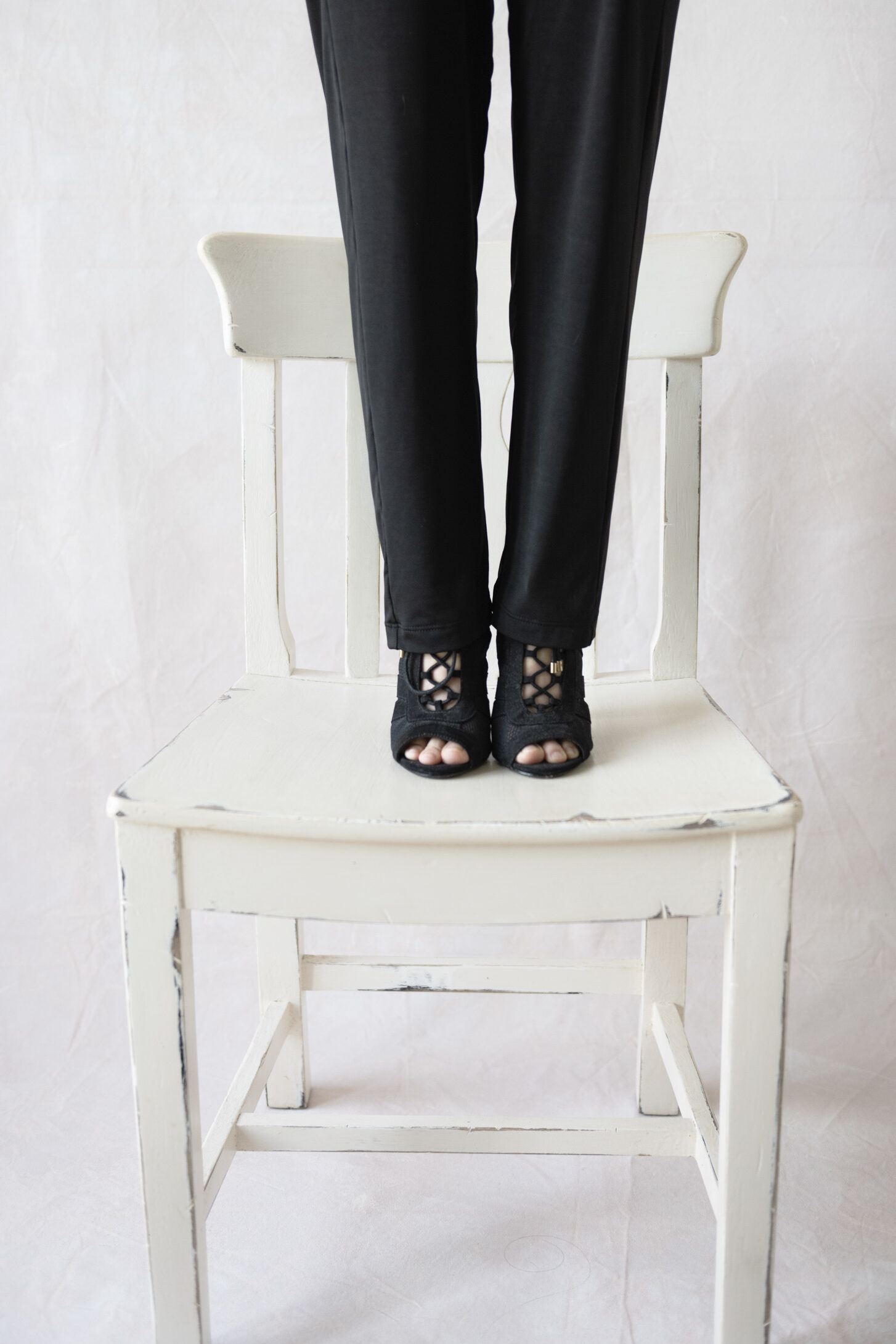 SQP personal branding photoshoot in studio with woman standing on chair only legs and shoes visible. thebrandstudio.au