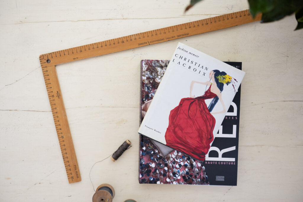 dressmaker ruler, threads and fashion design books  on work table