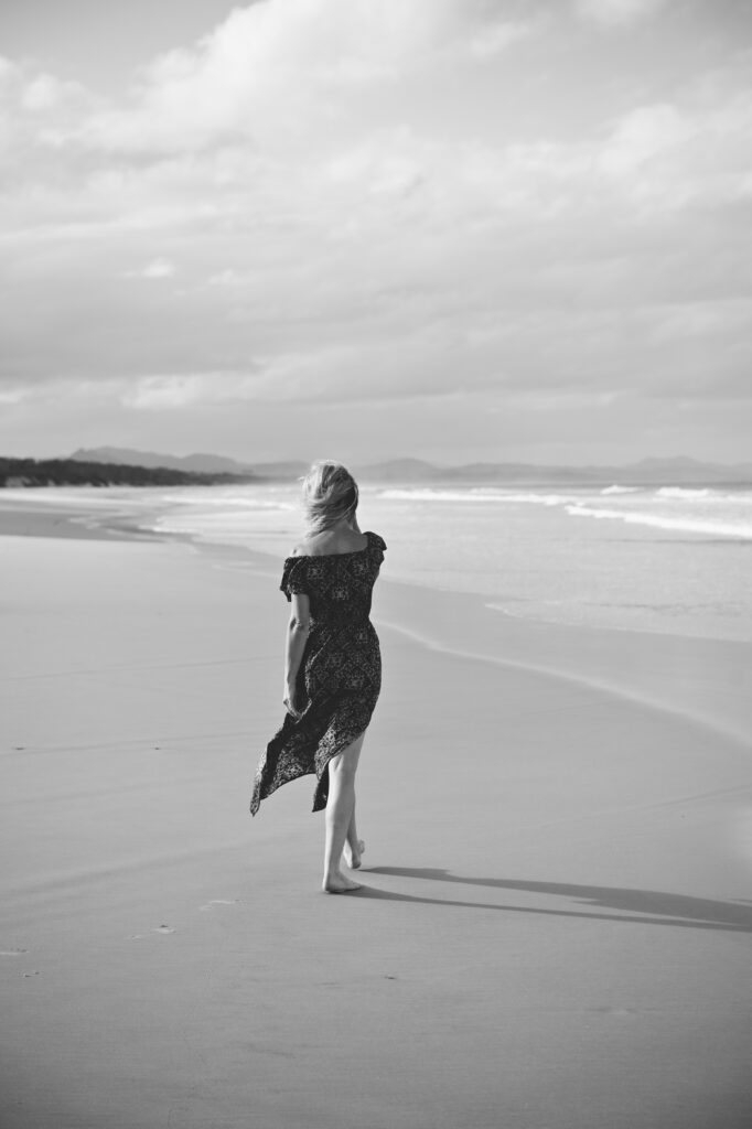 TBS SQP Custom brand imagery showing woman walking on windy deserted beach.  